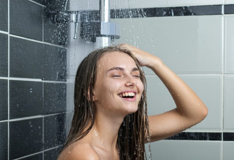 Smiling person enjoying a shower.